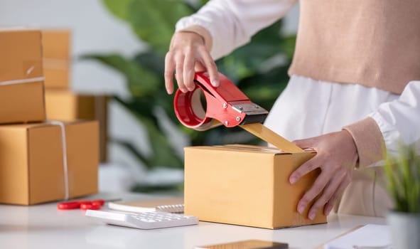 SME business entrepreneurs small in asia Preparing cardboard boxes in home office Small business operators preparing to ship to customers.