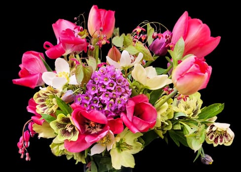 Romantic bouquet of the first garden flowers isolated on black background. The art of flower arranging