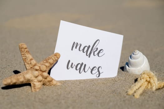 MAKE WAVES text on paper greeting card on background of starfish seashell summer vacation decor. Sandy beach sun coast. Holiday concept postcard. Getting away Travel Business concept