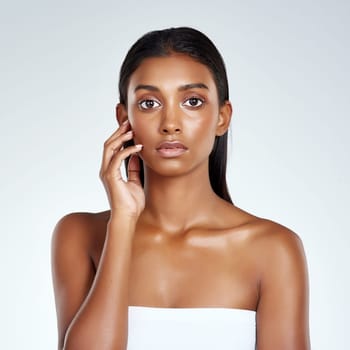 Beauty, studio and portrait of Indian woman with skincare from dermatology in mockup space. Face, makeup and girl with confidence from healthy facial or pride from cosmetics in white background.