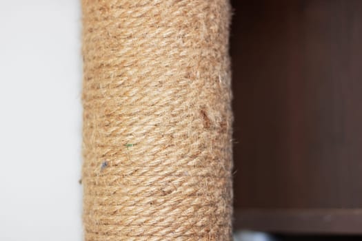 An artful artifact made of wood and metal, this scratching post features a cylindrical shape wrapped in wool rope. The patterned texture adds a touch of style to this rectangular design