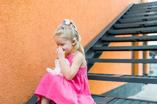 Child girl with hearing aids and cochlear implants having fun outdoor speak and playing. Copy space and empty place for advertising.