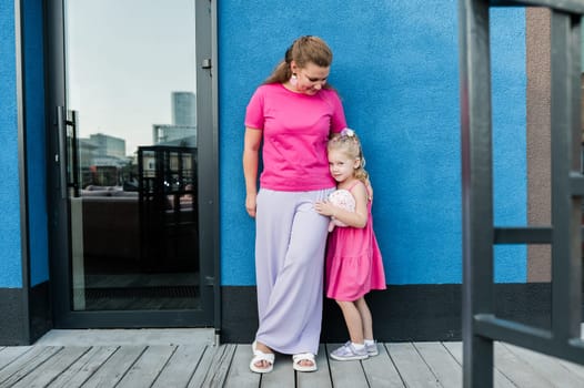 Mother holds and have fun her child with hearing aids and cochlear implants summer outdoor . Deaf and health concept. Diversity and inclusion. Copy space.