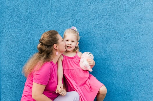 Mother holds and have fun her child with hearing aids and cochlear implants summer outdoor . Deaf and health concept. Diversity and inclusion. Copy space.