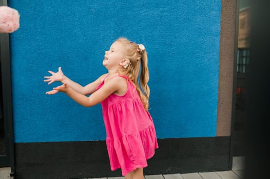 Child girl walks and have fun outdoor with cochlear implant on the head. Hearing aid and treatment concept. Copy space vertical.