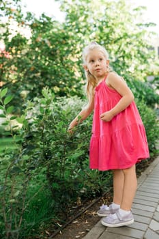 Child girl walks and have fun outdoor with cochlear implant on the head. Hearing aid and treatment concept. Copy space vertical.