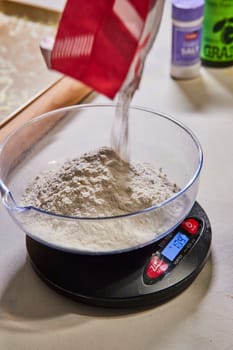 Precision in home cooking with flour being accurately weighed for homemade pasta in a Fort Wayne kitchen.