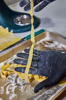 Professional chef in Fort Wayne, Indiana preparing fresh homemade fettuccine pasta in a commercial kitchen