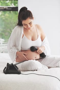 Pregnant woman, telephone and relax on bed for communication, happiness and contact in bedroom. Mother, smile and conversation in house for care, connection and phone on tummy for voice or sound