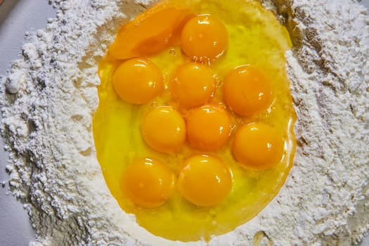 Fresh Indiana eggs and flour ready for homemade pasta making - an enticing overhead view of raw baking ingredients.