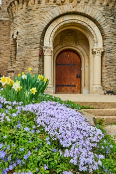 Springtime at Bishop Simon Brute College, Indiana - a vibrant bloom of periwinkles and daffodils adorning the historical stone architecture.