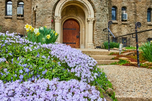 Spring blooms at historic Bishop Simon Brute College in Indianapolis, showcasing nature's renewal against timeless stone architecture.