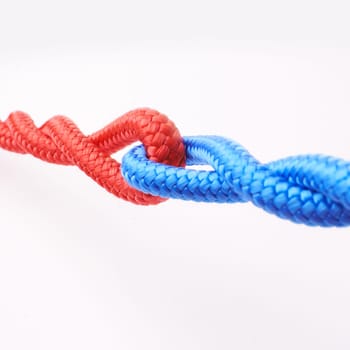 Ropes, connected and tied together in studio for fastening, towing and securing heavy equipment in construction. Cordage, colourful and strong for pulling, strength and hauling furniture safely.