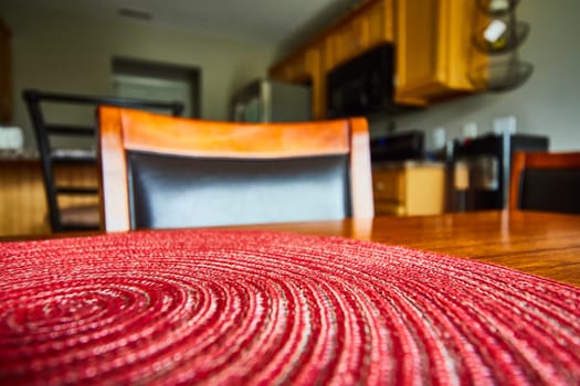 Cozy dining scene in Fort Wayne, Indiana- inviting home interior with focus on a red placemat on a wooden table.