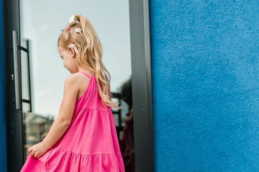 Child girl with hearing aid and cochlear implantation system. Kid with hearing problems walks outdoor in summer. Inclusion and diversity