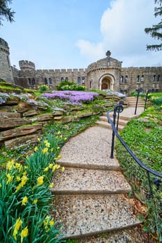 Springtime at Bishop Simon Brute College, Indiana - vibrant flowers frame the entrance to the historical stone castle, symbolizing renewal and heritage.