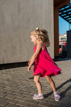 Child with hearing problem and cochlear implant dance in street, deaf kid began to hear. Hearing loss in childhood and treatment concept. Copy space and empty place for text.