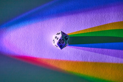 Vibrantly casting a rainbow shadow, a 20-sided die symbolizes chance and diversity in this abstract macro shot from Fort Wayne, Indiana.