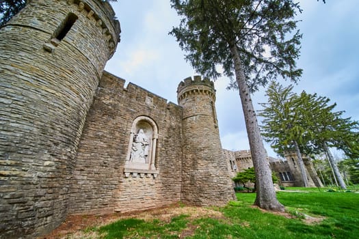 Majestic medieval castle at Bishop Simon Brute College, Indiana, showcasing robust architecture against a cloudy sky backdrop