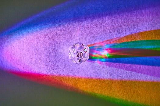 Macro view of a transparent D20 dice casting a vibrant rainbow spectrum on a surface, symbolizing gaming, science, and creativity