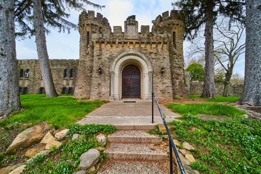 Springtime view of the historic Bishop Simon Brute College entrance in Indianapolis, a medieval castle symbolizing heritage and strength.