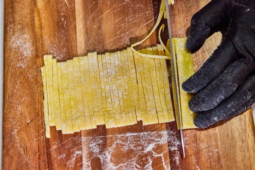 Handcrafted Art of Pasta Making in Fort Wayne, Indiana - Freshly Cut Tagliolini on Rustic Cutting Board.