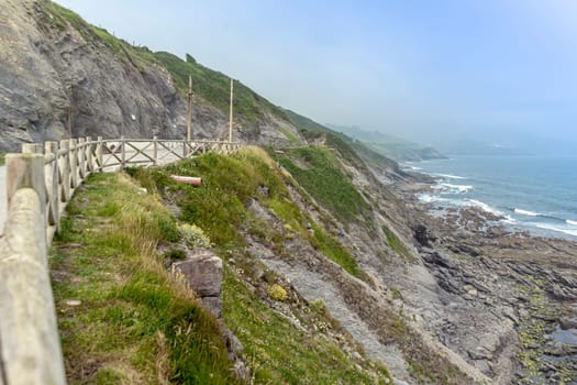 mountain trail enclosed by a wooden fence next to the Atlantic Ocean