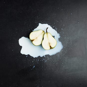 Spill, cream and fruit by dark background for above with pear, smoothie and wellness. Dairy, fresh produce and liquid with protein on countertop for healthy diet, green and milk with weight loss.