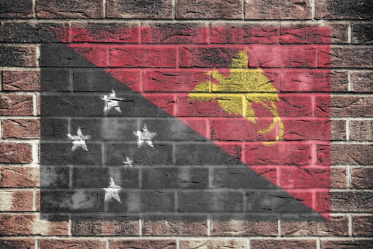 A Papua New Guinea flag on old brick wall background Black white red yellow Southern Cross raggiana bird of paradise