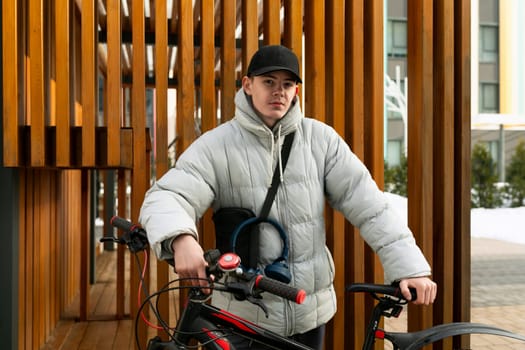 A young Caucasian man with a gray jacket and black cap rented a bicycle.