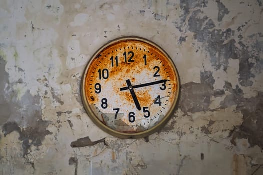 Old broken rusty wall clock in an abandoned building in Pripyat, Chornobyl Exclusion zone, Ukraine. Time flows concept.