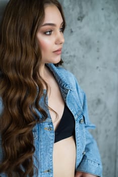 Woman in jeans jacket on studio background