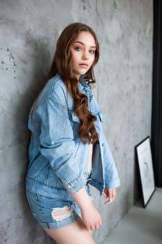 Woman in jeans jacket on studio background