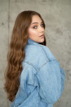 Woman in jeans jacket on studio background