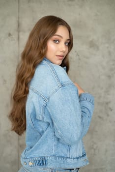 Woman in jeans jacket on studio background