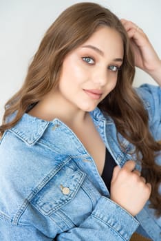 Woman in jeans jacket on studio background