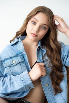 Woman in jeans jacket on studio background