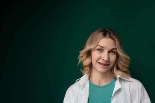 A woman wearing a white coat smiles directly at the camera. She exudes confidence and positivity in her expression, showcasing a sense of warmth and professionalism.