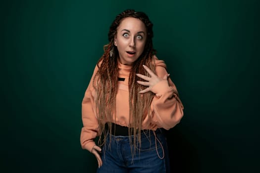 A woman with flowing long hair looks surprised, her eyes wide and mouth slightly open. Her expression conveys shock or astonishment as she gazes ahead.