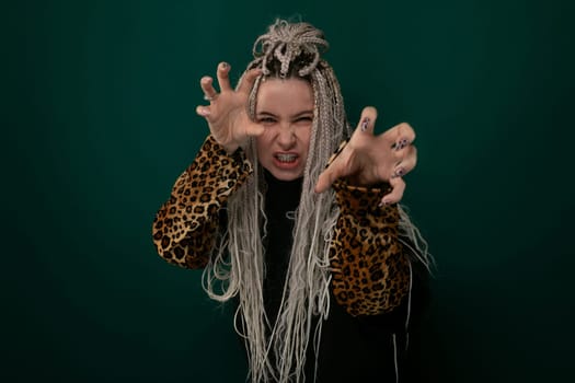 A woman with dreadlocks is standing with her arms raised, showing an expression of empowerment. She is holding her hands up high in the air.