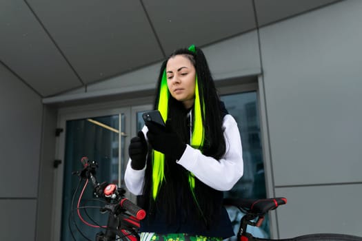 A woman with long hair is pictured wearing a vibrant yellow and black scarf. Her hair cascades down her back as she confidently wears the striking scarf around her neck.