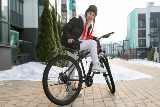Lifestyle concept, Caucasian woman with a bicycle near the house in winter.