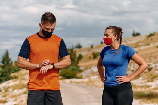 A couple dressed in sportswear runs along a scenic road during an early morning workout, enjoying the fresh air and maintaining a healthy lifestyle.