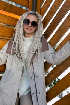 A woman with long blonde hair is stylishly wearing sunglasses, shielding her eyes from the sun. Her hair flows freely as she confidently gazes ahead. The sunglasses add a chic touch to her look.