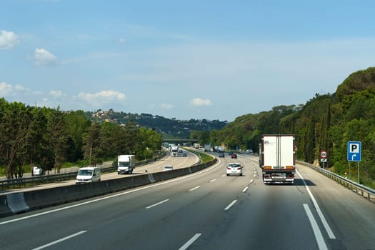 Hostalric, Spain - May 24, 2023: Cars and trucks drive on a busy highway while commuters navigate through heavy traffic.