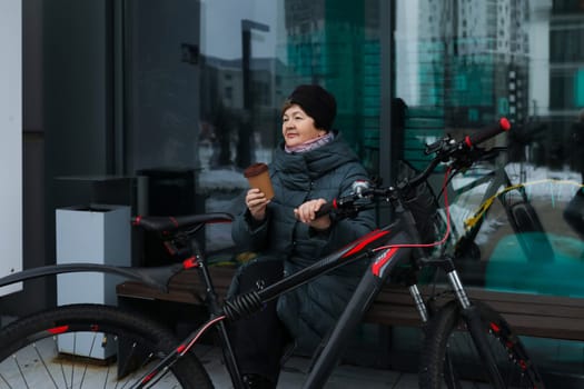 An elderly woman went outside with a bicycle.