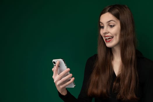 A woman is depicted holding a cell phone in her right hand, with her fingers wrapped around the device. Her hand is positioned slightly raised in front of her body, suggesting she is either about to use the phone or has just finished using it.