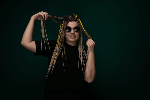 A woman with long dreadlocks on her head is striking a pose while someone takes her photo. She is looking directly at the camera with a confident expression, showcasing her unique hairstyle.