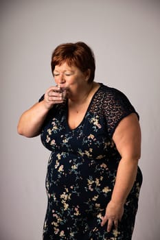 Fifty something woman drinking a shot of alchool