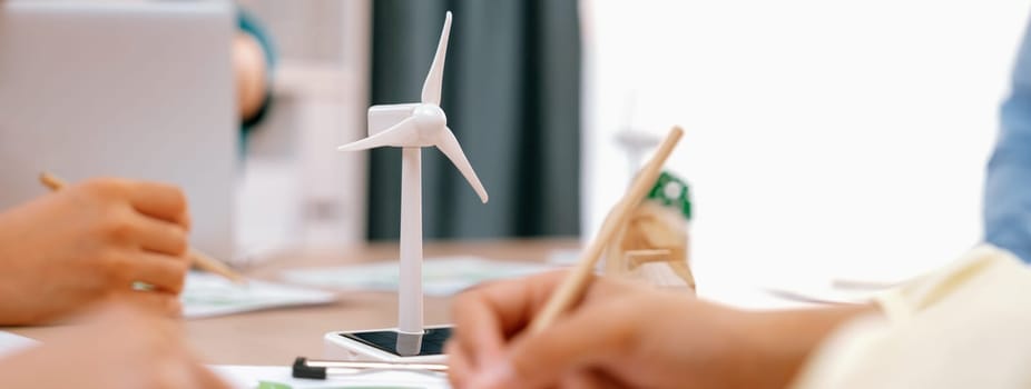 Green business meeting represented renewable energy. Skilled businesspeople discuss green business investment at table with environmental documents. Closeup. Focus on hand. Delineation.